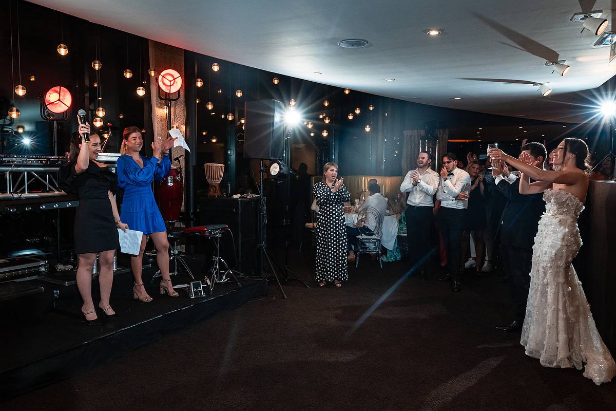 Les mari&eacute;s partagent un moment de gloire, saluant leurs invit&eacute;s comme des c&eacute;l&eacute;brit&eacute;s sur sc&egrave;ne, immortalis&eacute;s par Sebastien CLAVEL Photographe mariage Lyon au c&oelig;ur du Pavillon du Casino Lyon vert