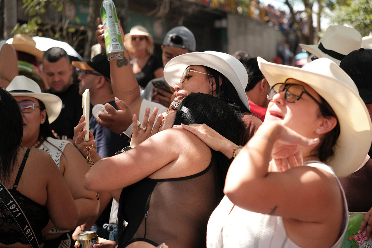 Spectators in white sombreros celebrating together along the Feria de las Flores parade route