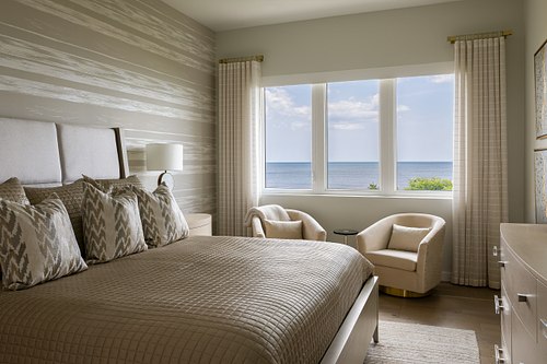 Interior design photography of a primary suite in a Ponte Vedra Beach mansion, showcasing a gold-leaf architectural accent wall, custom high-end millwork, and luxury coastal finishes.