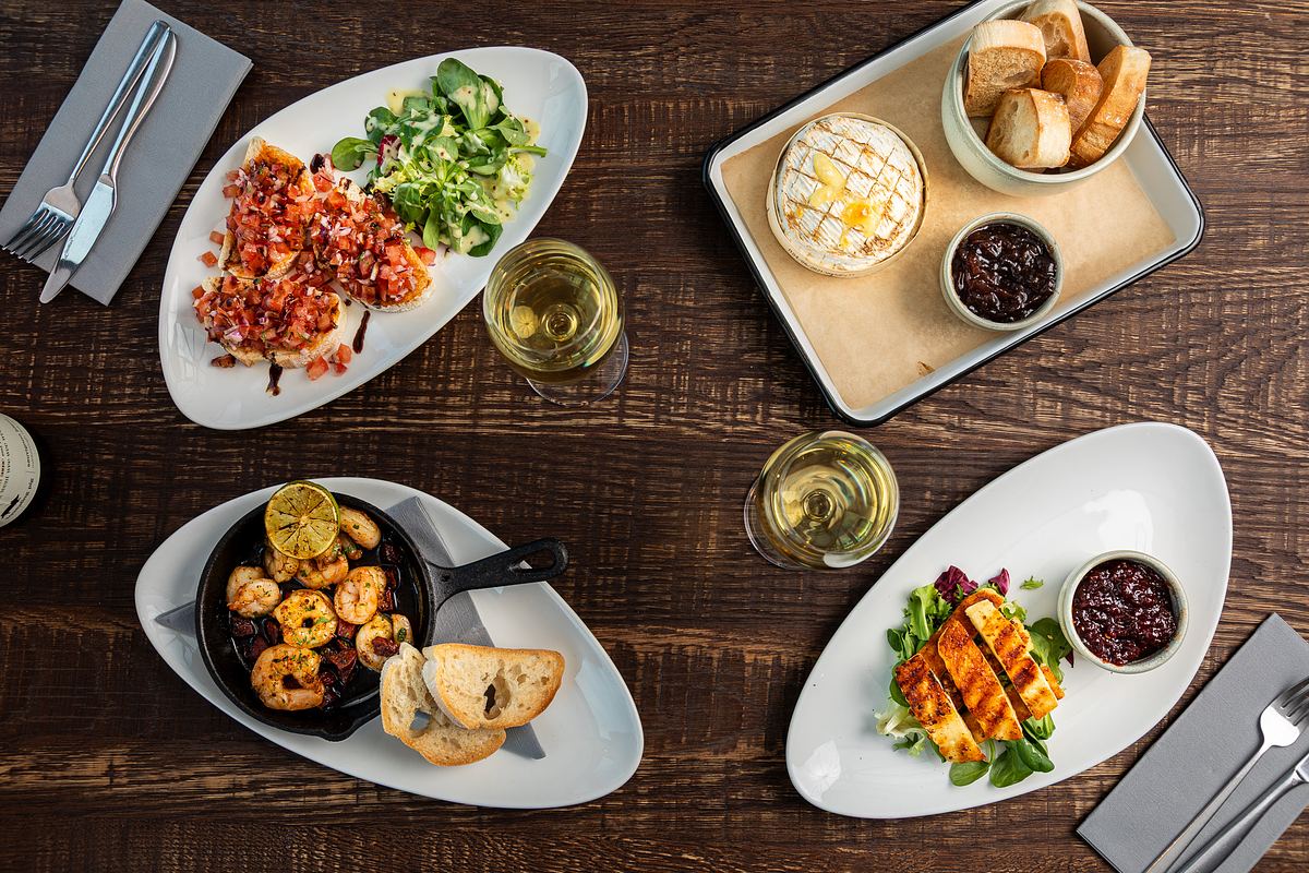 A flat lay of various dishes on a dark table top.