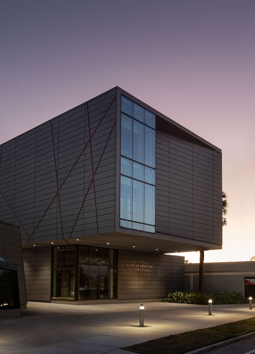 A vertical twilight architectural photograph of a modern glass and steel building on the Ringling College of Art and Design campus in Sarasota, Florida.