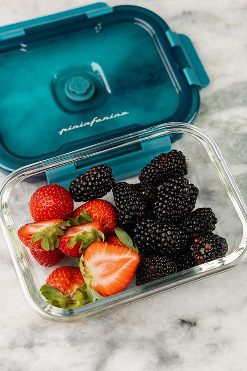 Envase de vidrio con vaciado en vacío lleno de fresas y blueberry sobre la mesa en supermercado de Panamá