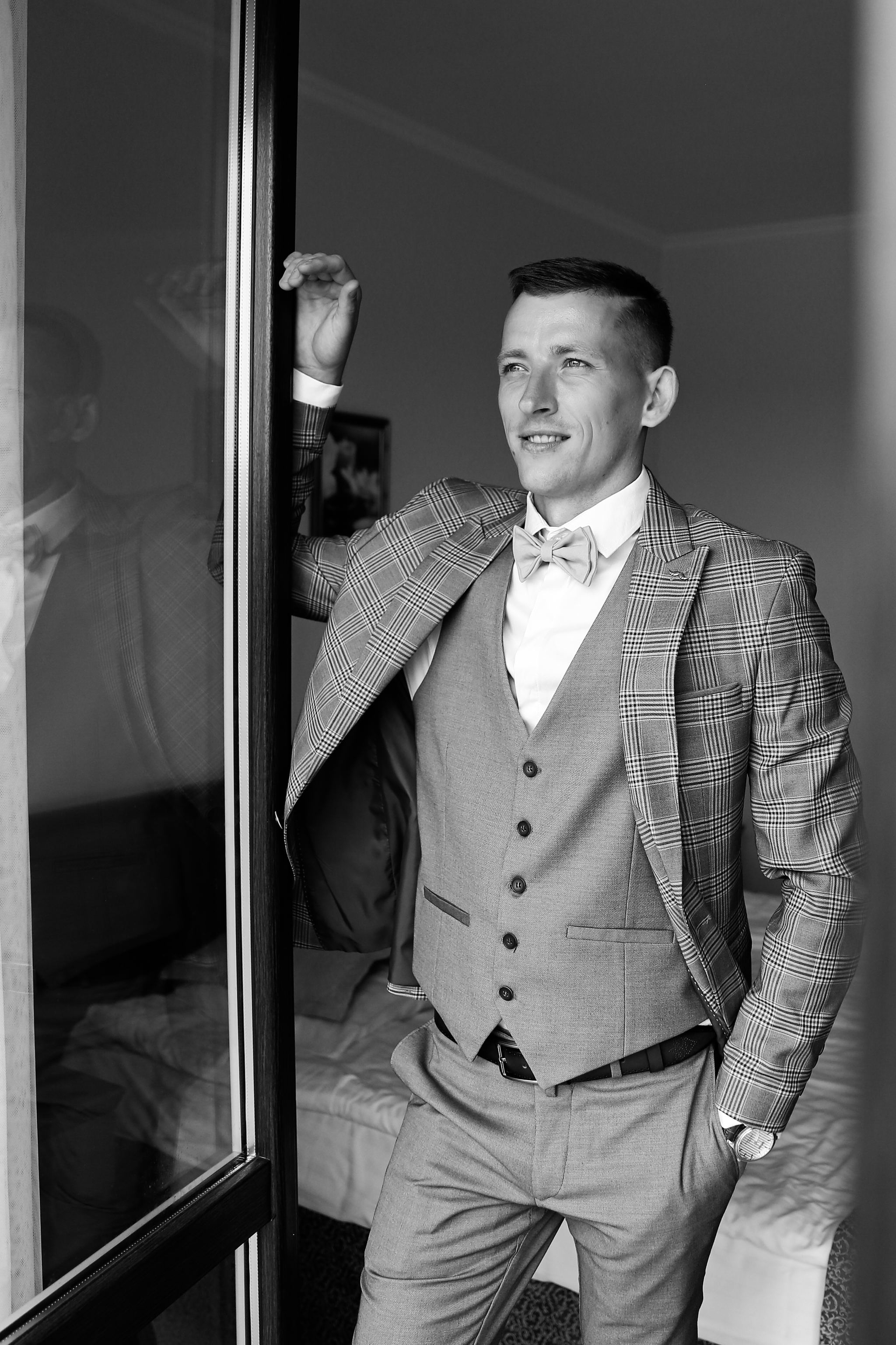 Black and white bridal portrait by the window before the wedding ceremony
