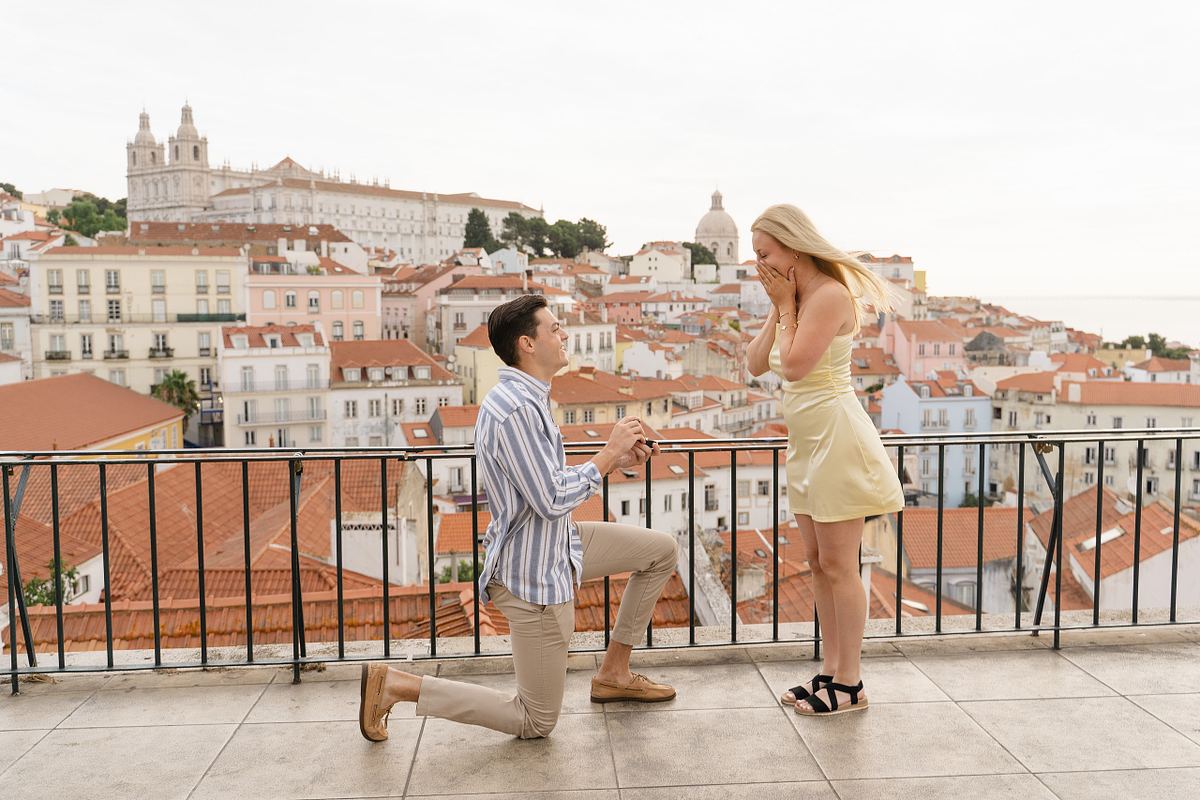 Man proposing to his partner at a viewpoint overlooking Alfama in Lisbon