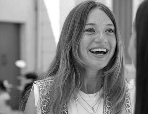 Portrait en noir et blanc d’une jeune femme souriante.