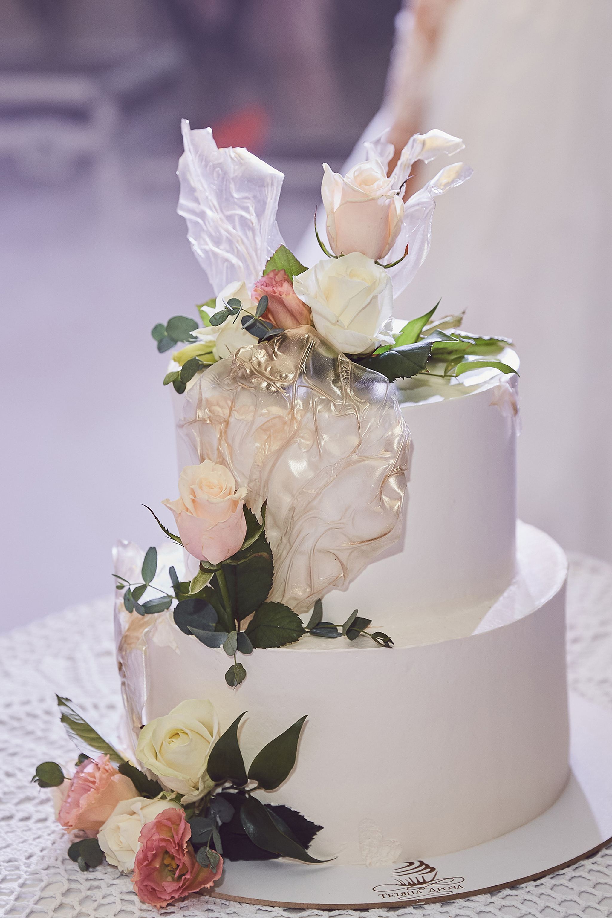 Elegant white wedding cake decorated with blush and ivory roses