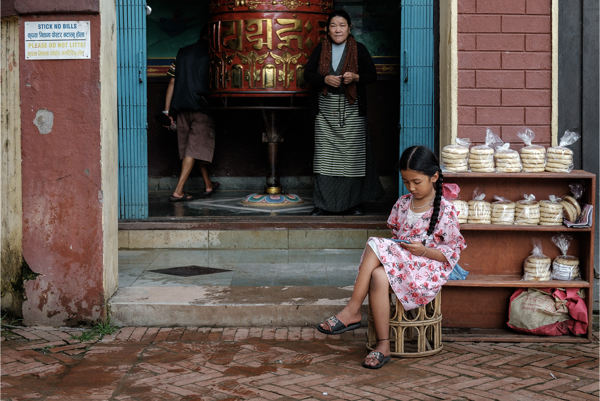Eye contact overpowering sharpness. Although the girl is sharper in the frame, the eye contact comes from behind and overpowers her presence
