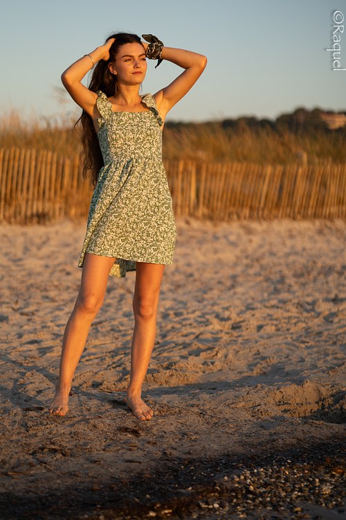Jeune femme posant sur le sable au coucher du soleil sur la plage de l’Almanarre à Hyères