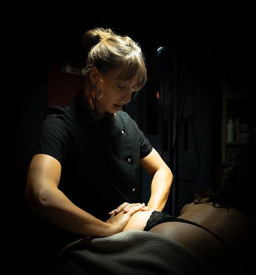 Praticienne réalisant un massage du corps dans un institut.