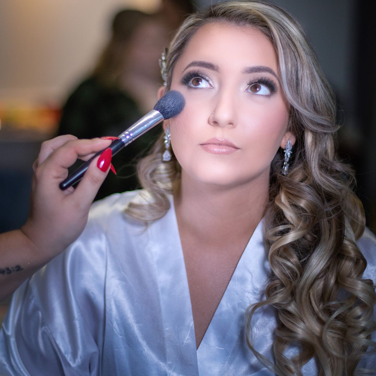 make-upartist adding finishing powder after finishing applying expert wedding make-up