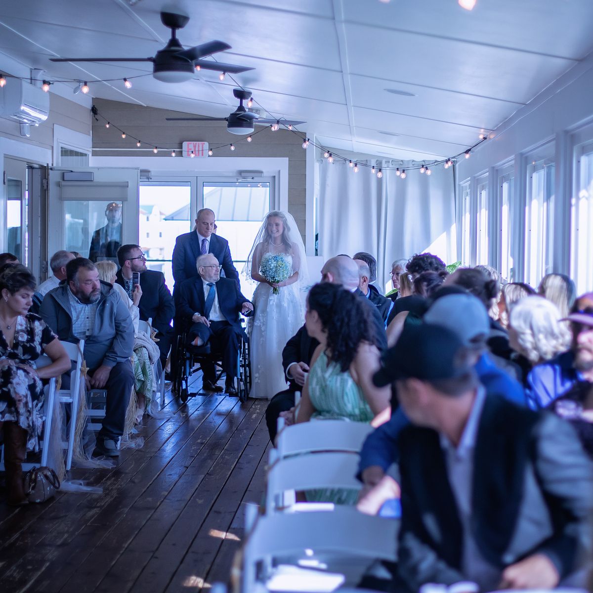 unplugged wedding ceremony at Irish Penny in lewes, delaware, the bride and her father walking down the aisle, the dad is in a wheelchair