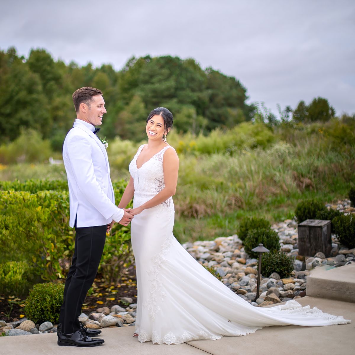 Natural light documentary wedding portrait of a bride and groom laughing together at Kylan Barn.