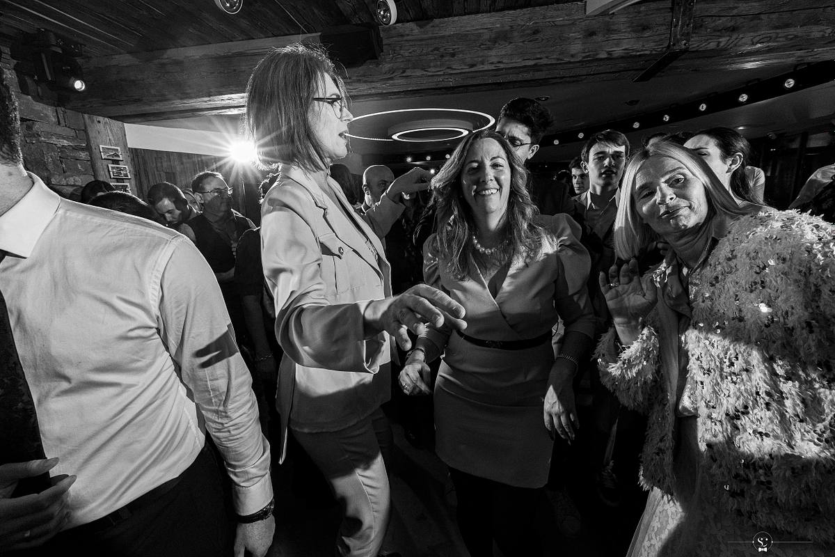 Cocktail et Soir&eacute;e de Mariage avec les invit&eacute;s et les mari&eacute;s qui s'amusent, sourient, s'embrassent et dansent. Les Rhodos La Clusaz Sebastien Clavel Photographe Mariage Lyon