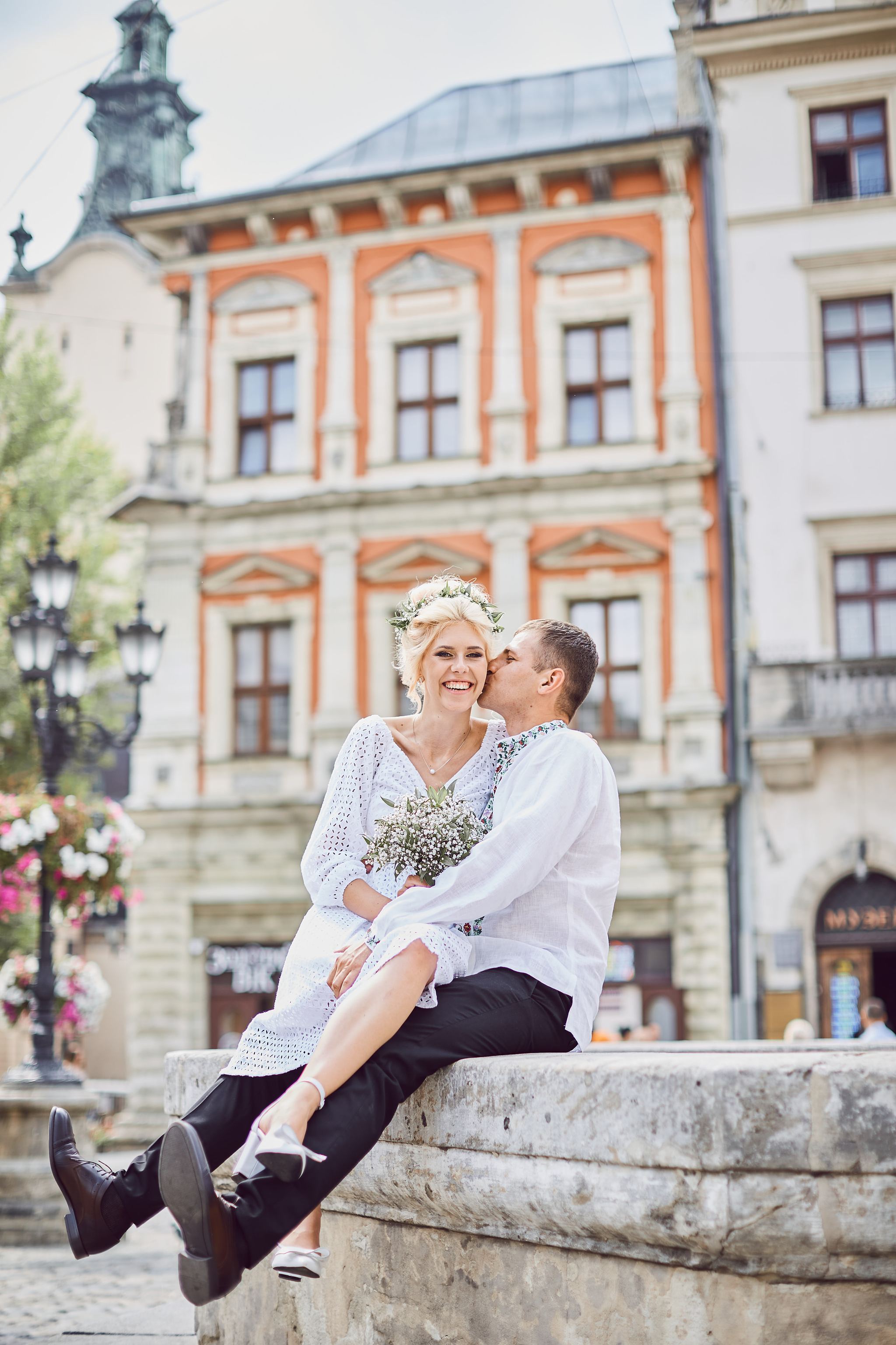 Bride and groom embracing beneath an archway