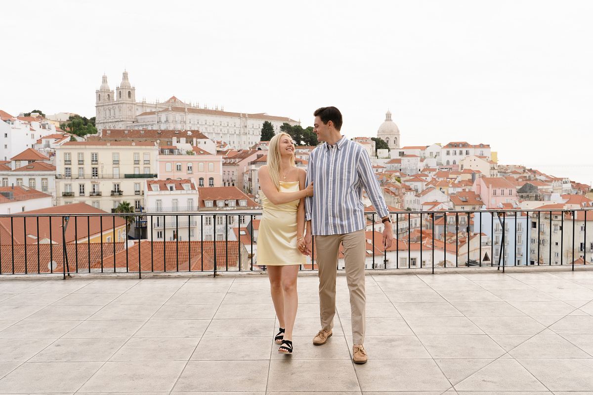 Engaged couple walking together at a scenic Alfama viewpoint