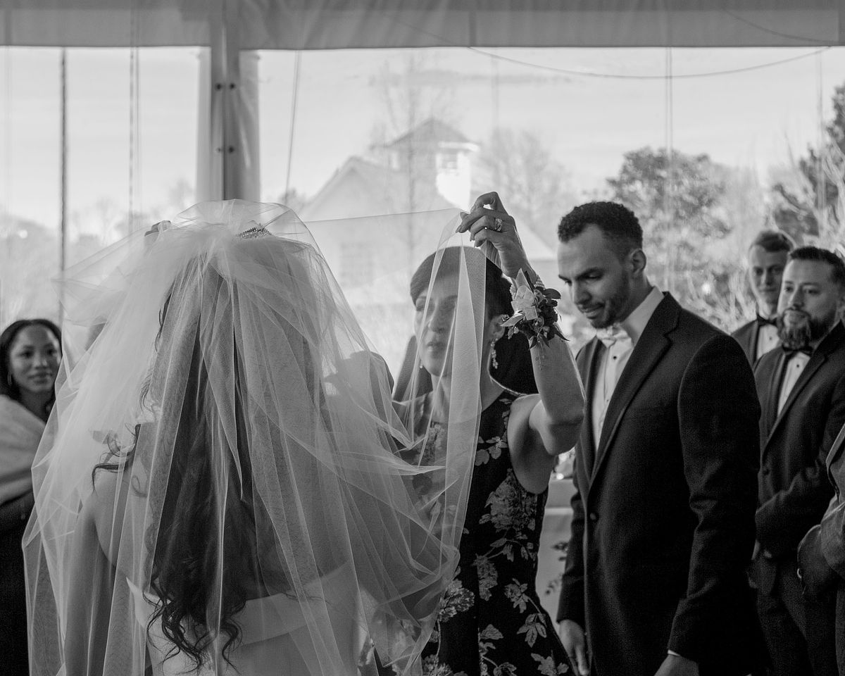 mother of the bride taking the blusher of the bride before the start of the ceremony at baywood weddings in millsboro, de