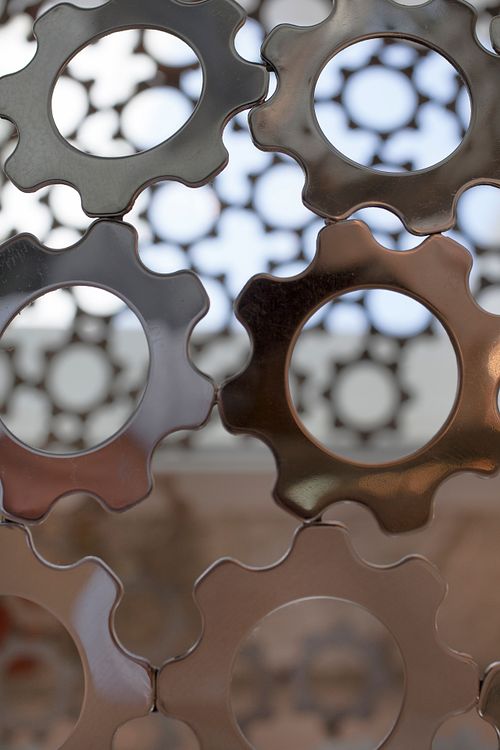 Détail de panneaux décoratifs en métal ajouré avec motifs géométriques circulaires, jeu de lumière et d’ombre en décoration intérieure