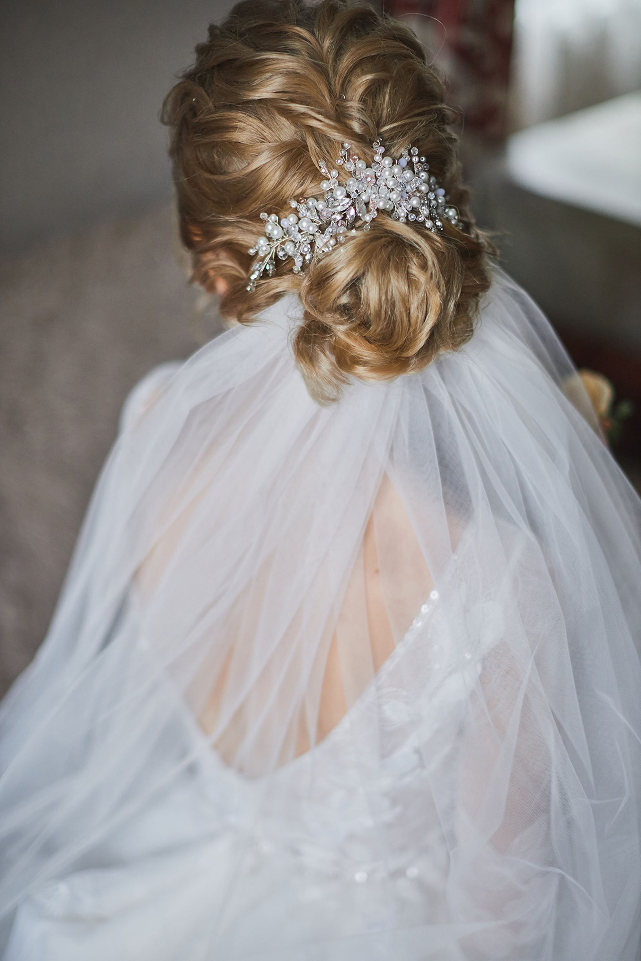 Bridal hairstyle with pearl hairpiece and flowing wedding veil