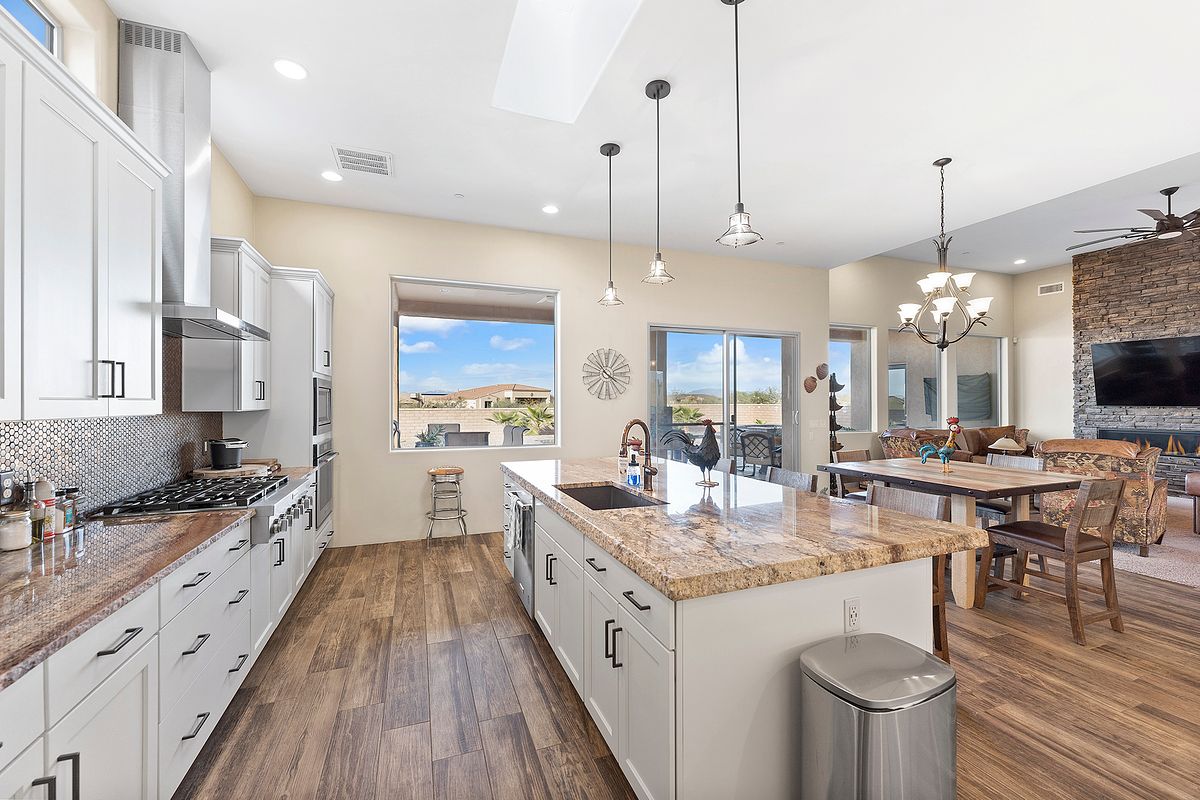 Farmhouse kitchen with marble island and open floor plan in Firestone Colorado home