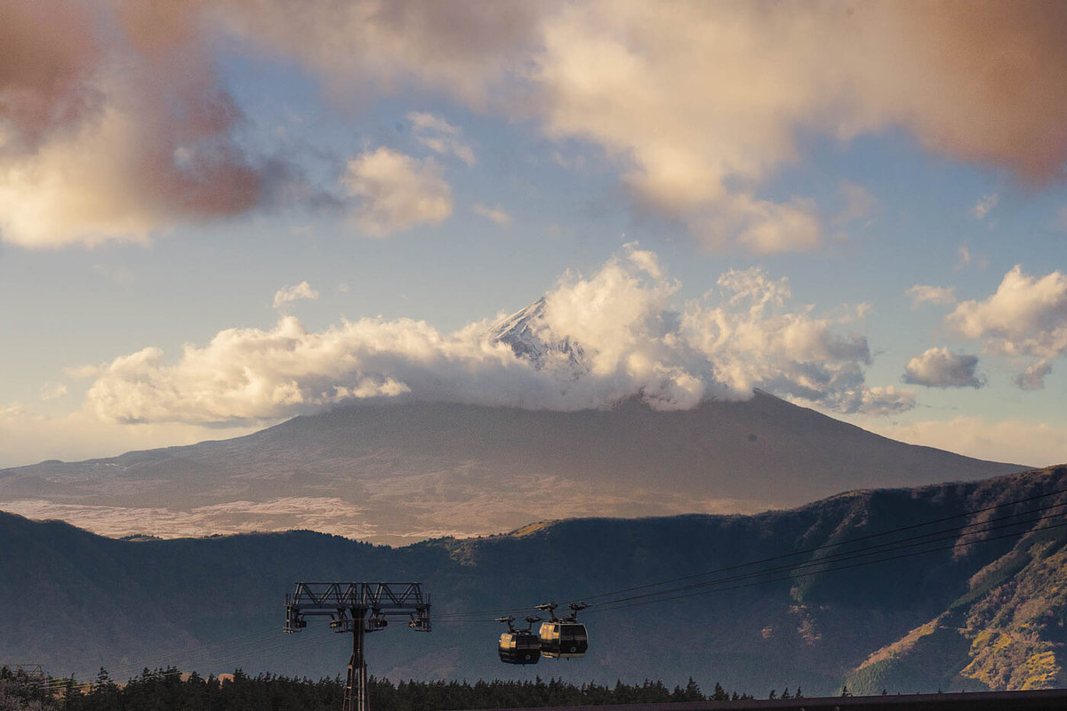 Le mont Fuji derrière les nuages vu d'Ōwakudani, cabines du téléphérique de Hakone au premier plan