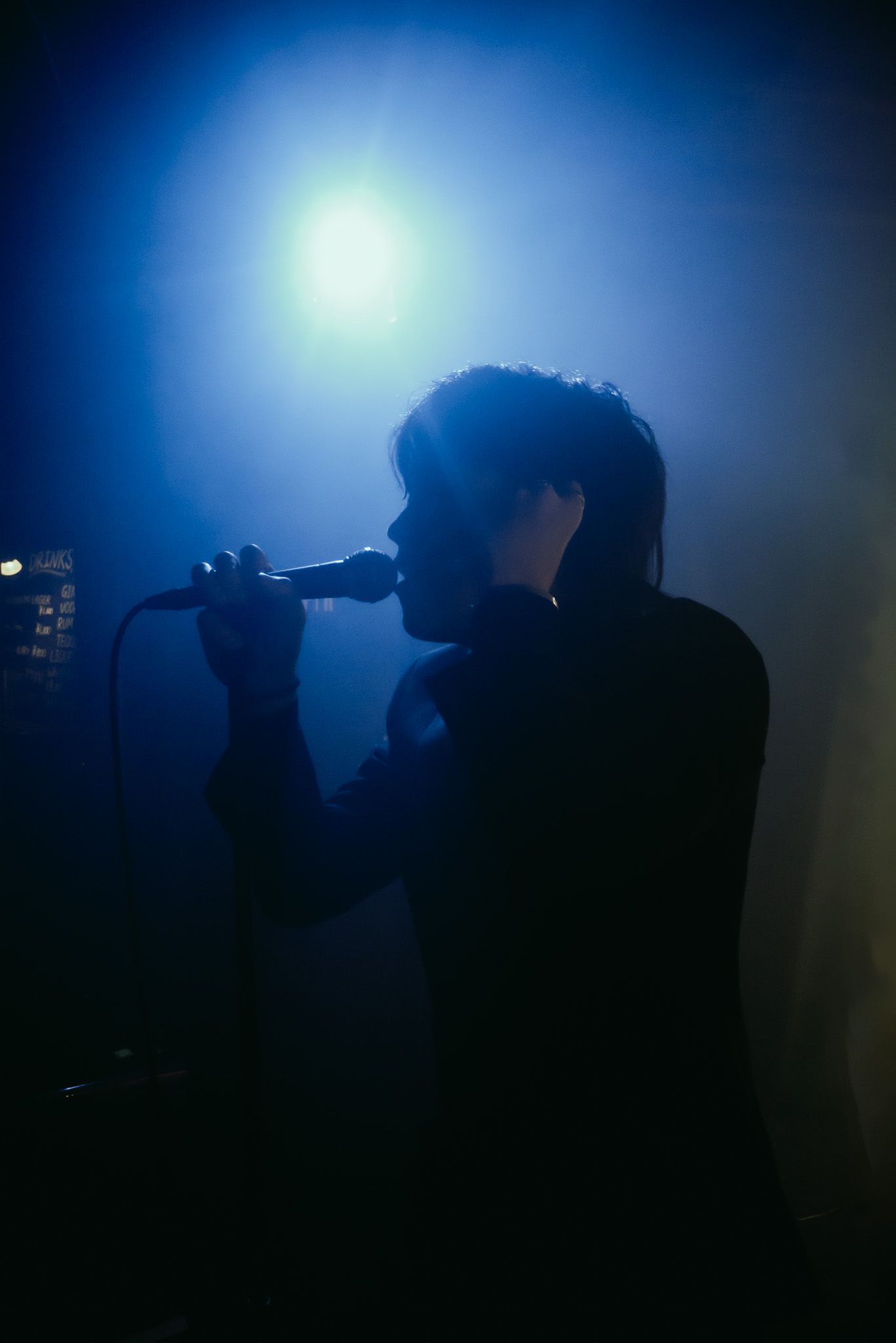 Silhouette d&rsquo;un chanteur sur sc&egrave;ne en lumi&egrave;re bleue, reportage d&rsquo;&eacute;v&eacute;nement