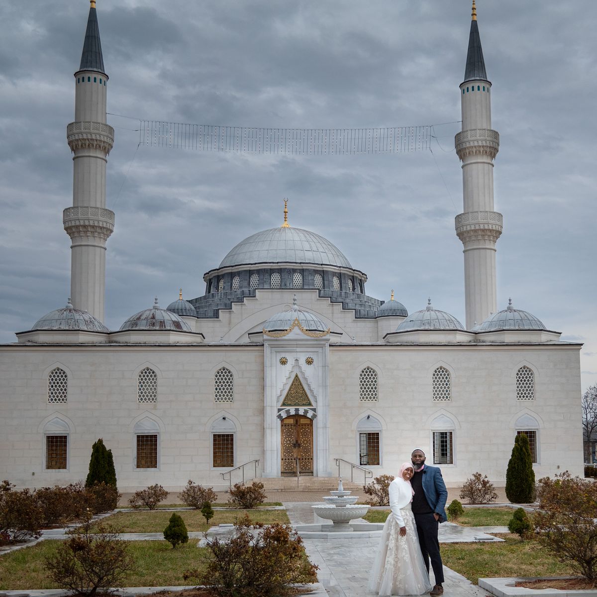 muslim mosque with newly wed couple posing in front after a traditional nika wedding in washington, dc