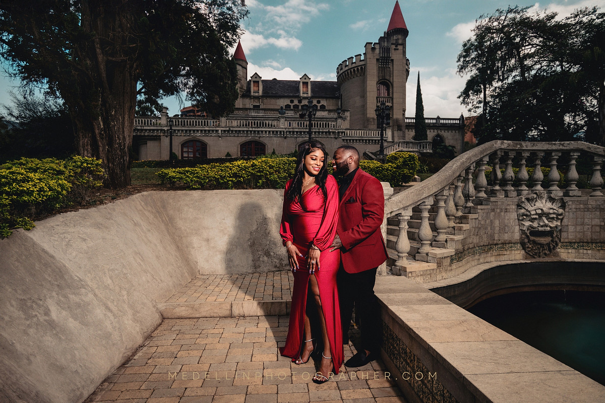 Couple in matching red outfits on the stone steps at El Castillo Museum in Medellin