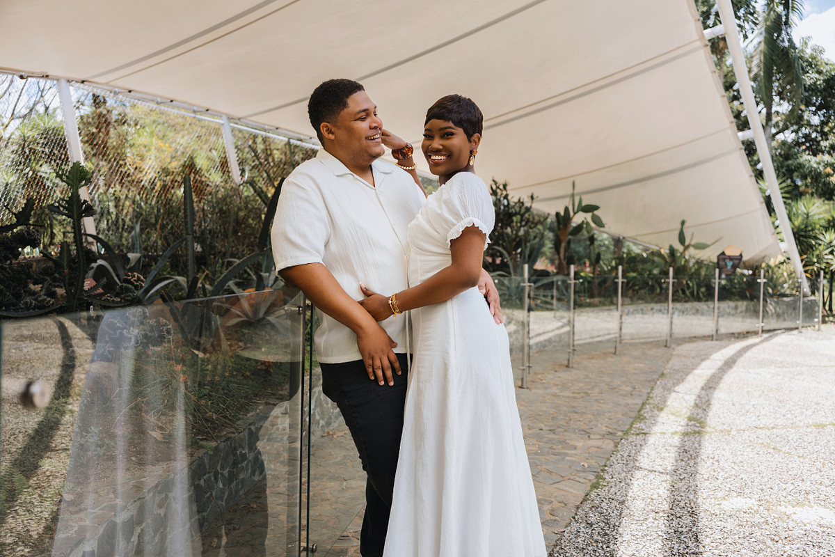 Couple dressed in white laughing together during a Medellin engagement session