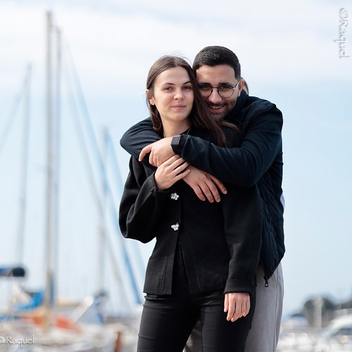 Couple enlacé devant un port de plaisance lors d’une séance photo lifestyle.