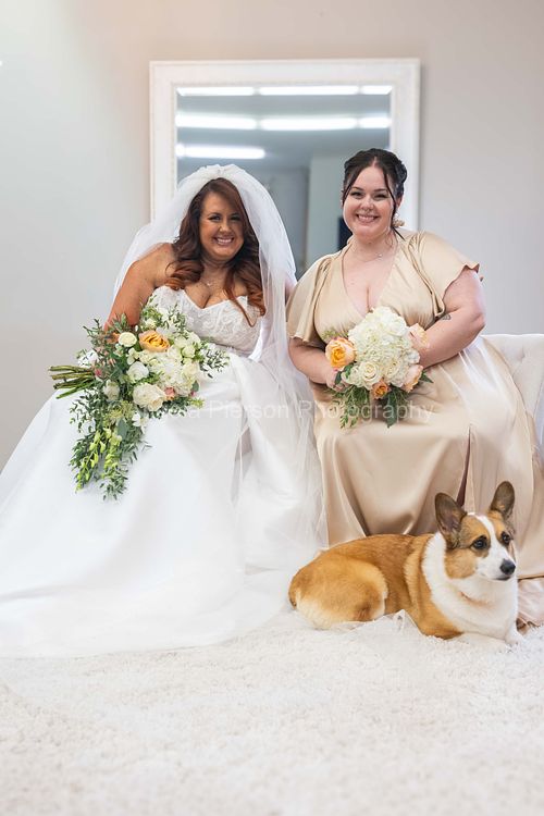Bride, Maid of Honor and a Corgi pose in stunning natural light in front of a mirror