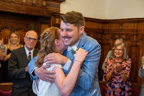 Emotionale Umarmung des Brautpaares während der Trauung