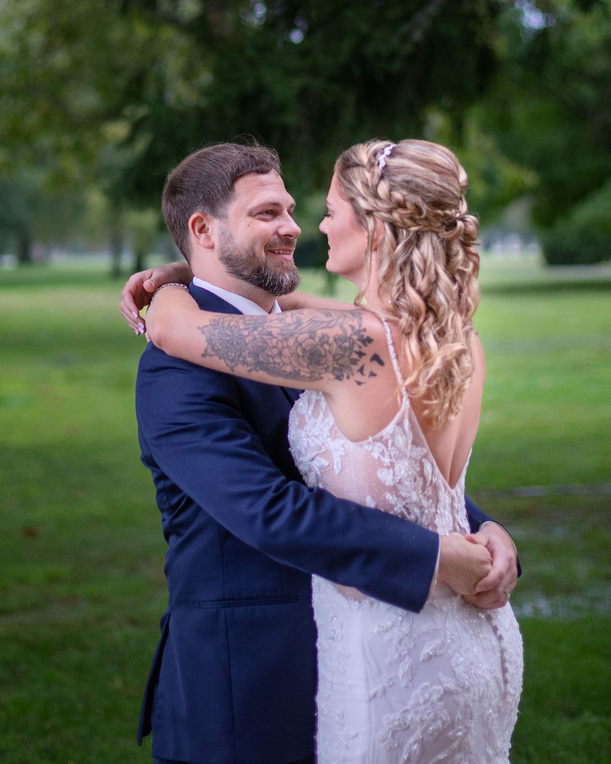 bride and groom smiling at each other in a close embrace on the grounds at ross mansion