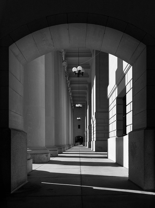 Fine art black and white architectural photograph of the historic Jacksonville Union Terminal concourse court by architect Kenneth M. Murchison, showcasing its monumental Neoclassical arches and deep shadows.