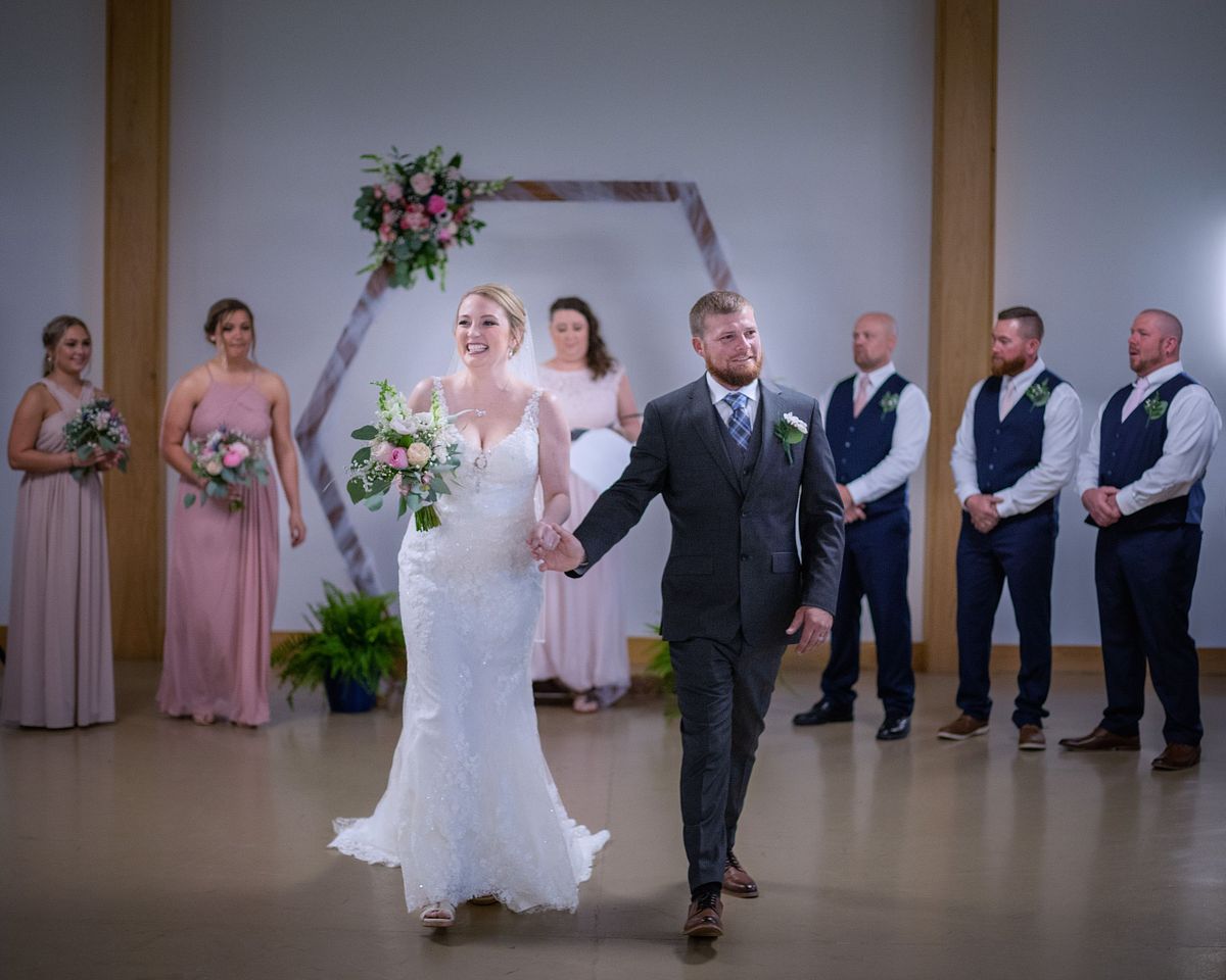 couple leaving after ceremony, holding hands and bride holding her flowers