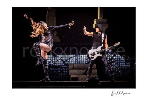 Horizontal color image of Rihanna and Nuno Bettencourt performing live on stage with Rihanna in dynamic motion and Nuno Bettencourt holding a white electric guitar