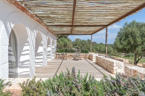 Terrasse couverte avec pergola en bois et vue sur le paysage depuis la finca Son Fonoll à Minorque. Photographie par Nicolas Karadimos.