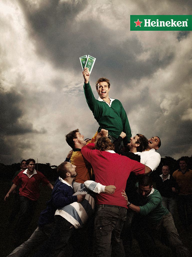 Rugby world cup advertising of guys in a scrum pushing one guy in the air who won tickets.