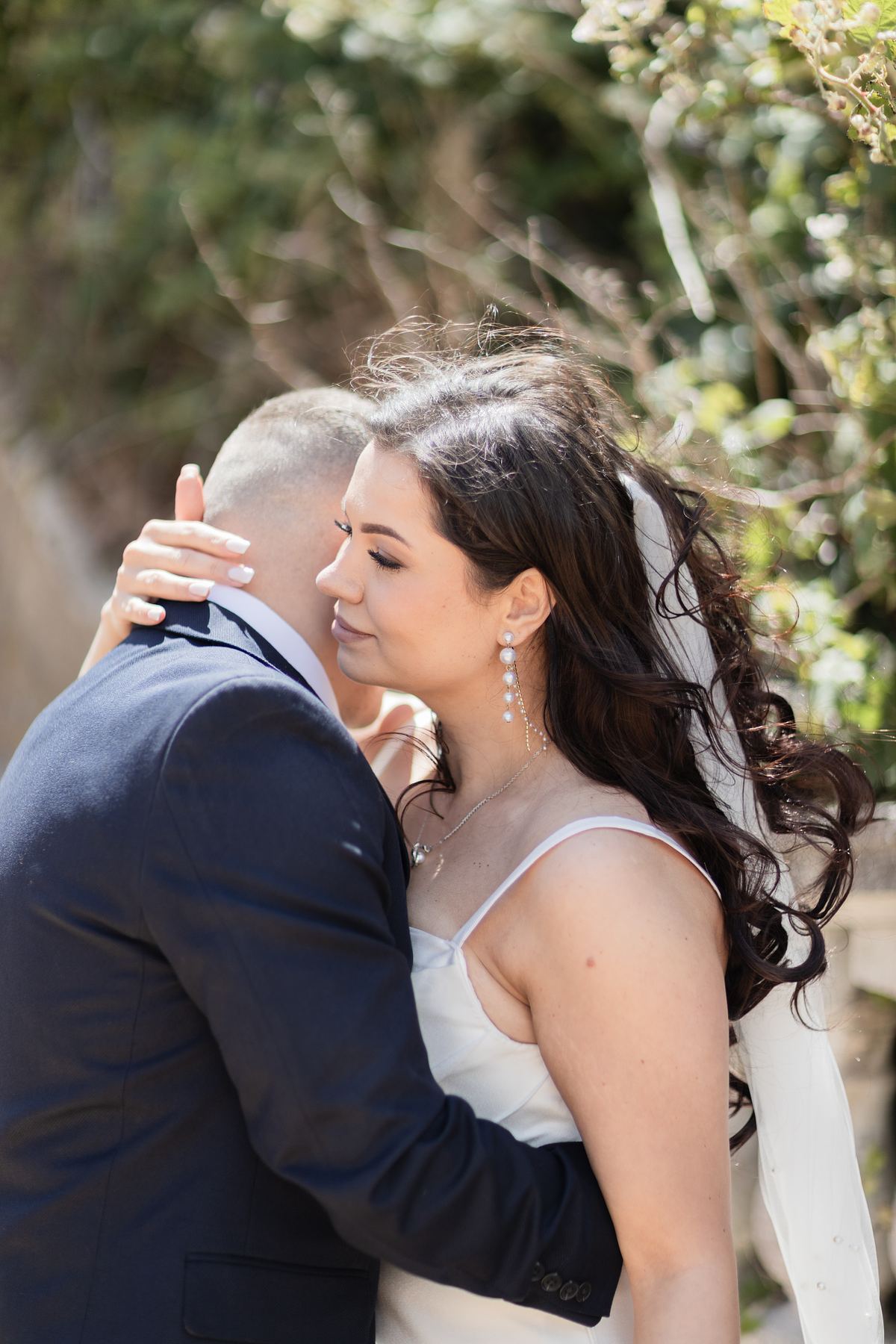 Close portrait of bride embracing groom outdoors at Barry Island, South Wales