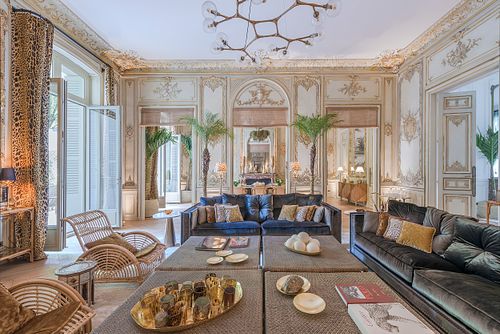 Grand salon haussmannien  rue du Faubourg Saint-Honoré avec canapés bleus, dorures et moulures au plafond. Photographie d’architecture intérieure par Nicolas Karadimos.