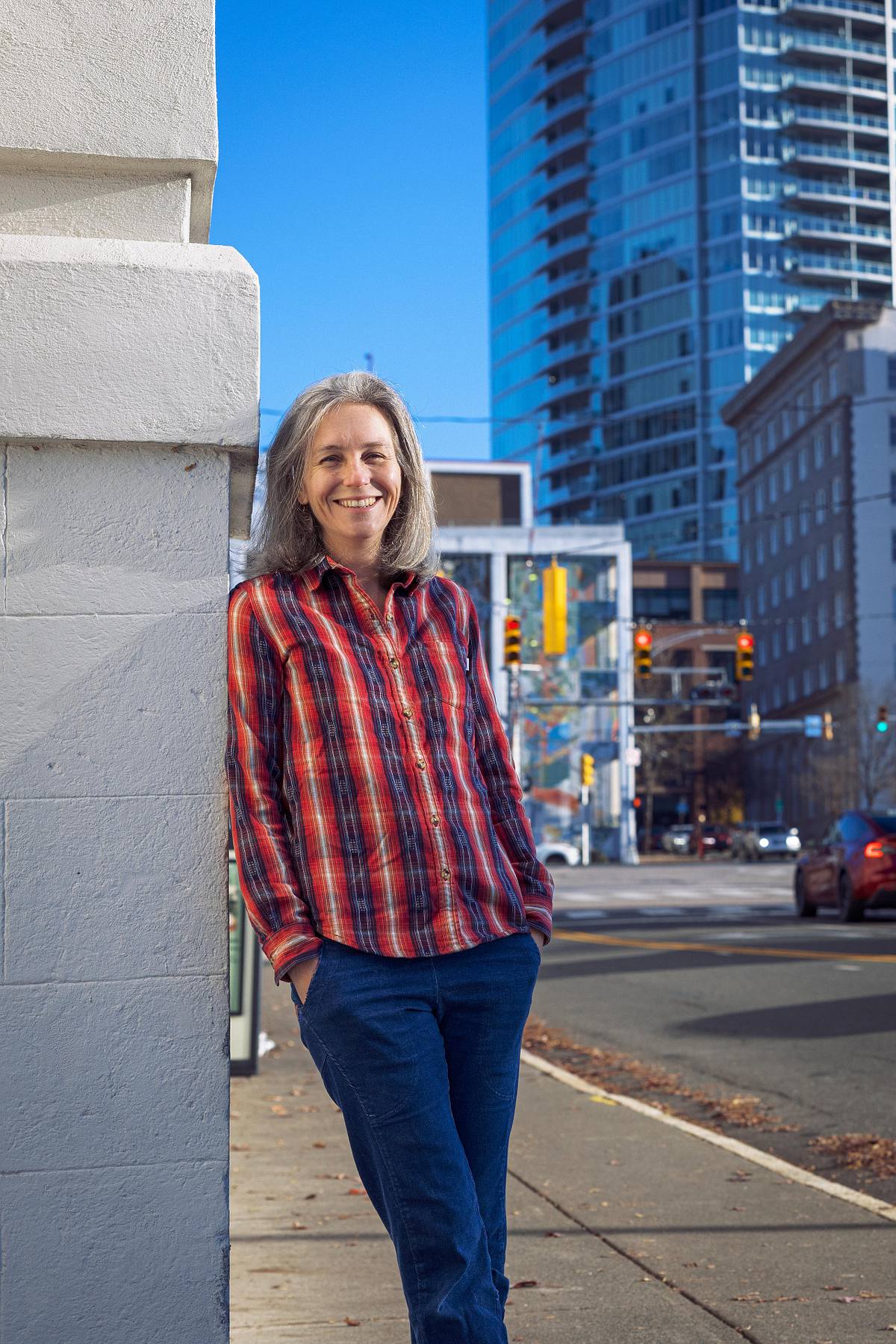 A small business owner poses for her website photo with downtown Durham, NC, as the backdrop